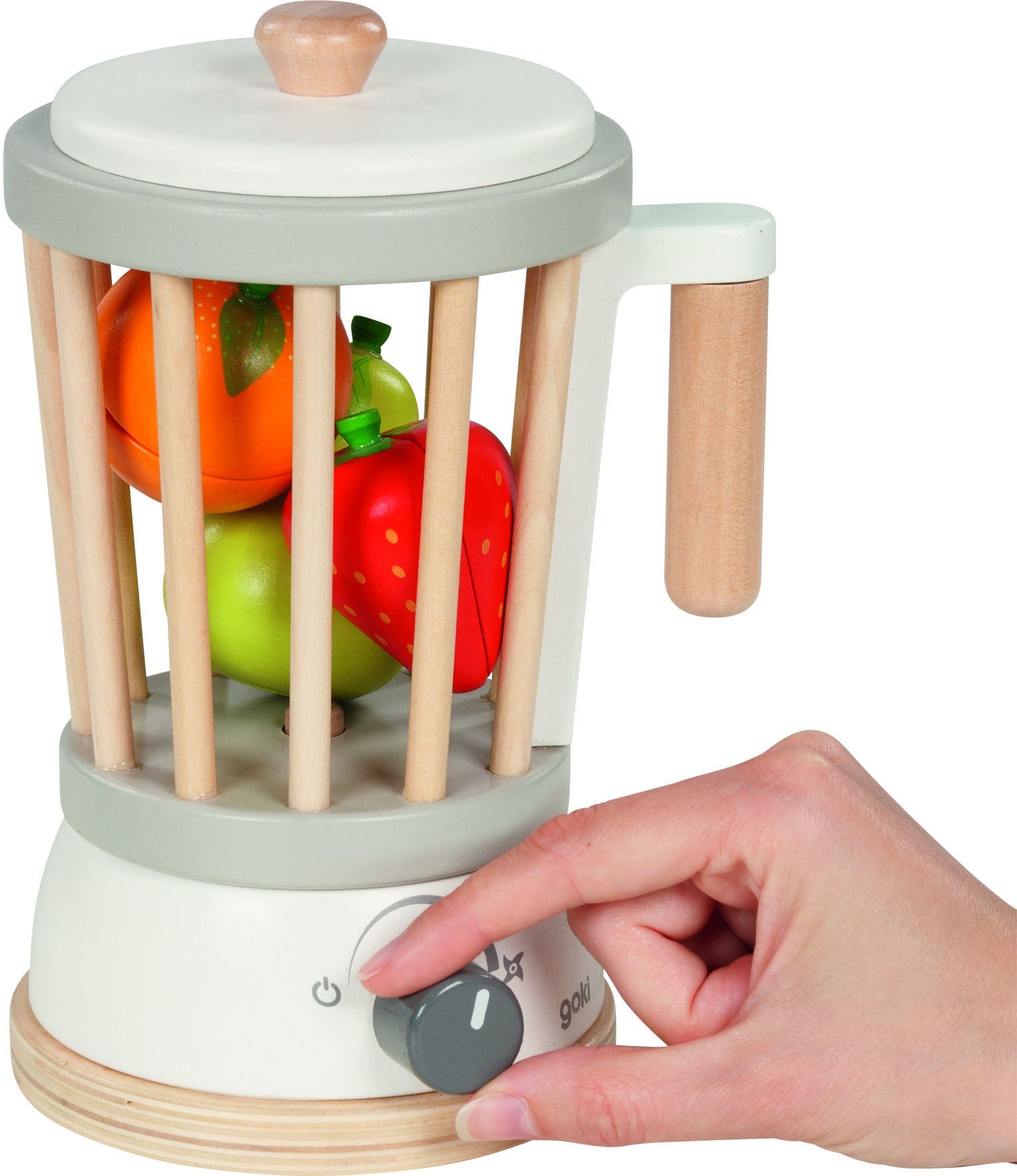 Ein Holz-Standmixer-Spielzeug mit Holzteilen und buntem Obst im Inneren; eine Hand dreht den Einstellknopf. Das Produkt ist für Kinder und Rollenspiele geeignet. Die Farben sind hauptsächlich hellgrau, weiß, holzfarben, rot, grün und orange.