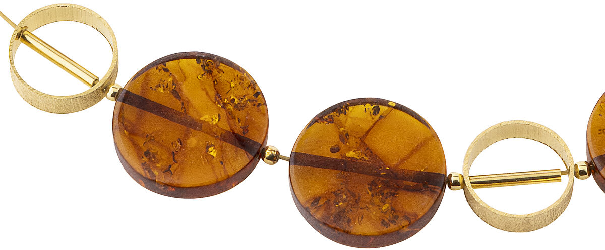 Bernsteincollier Modell Sinope mit vier runden Bernsteinperlen und dekorativen Goldelementen auf einem feinen Drahtcollier, mit verstellbarem Verschluss. Das Collier liegt elegant und leicht am Hals und eignet sich als exklusives Schmuckstück oder Geschenk.