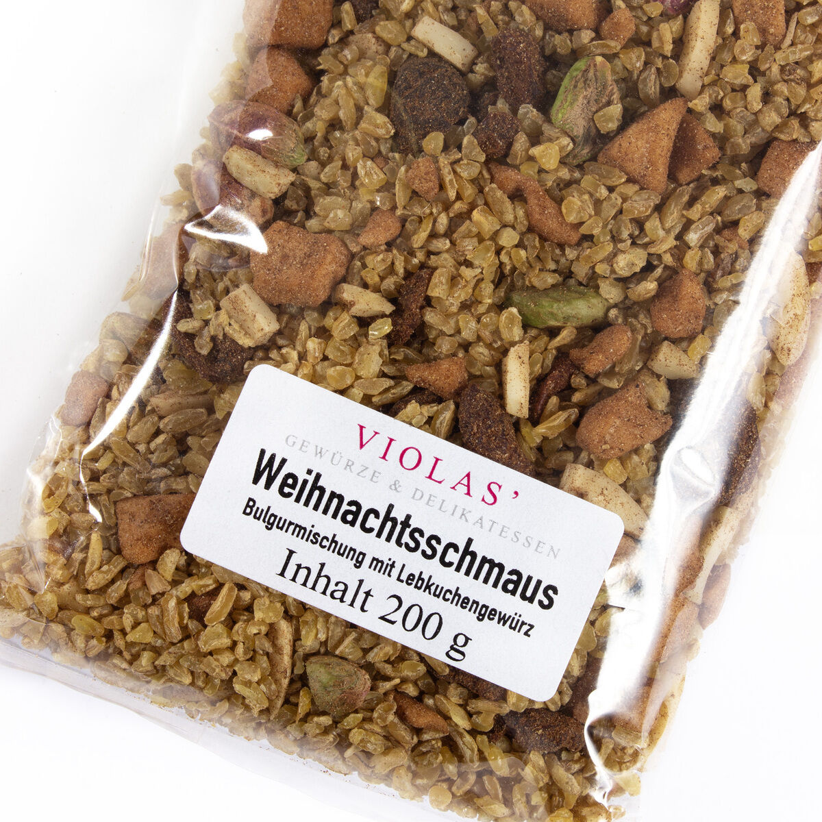 Ein Geschenkset namens 'Süsses Weihnachtshaus Geschenkset' enthält eine Tüte mit einer bunten Mischung aus Gewürzen und Lebkuchengewürz, die für die Weihnachtsfeier geeignet ist. Die Verpackung ist durchsichtig und zeigt den verführerischen Inhalt.