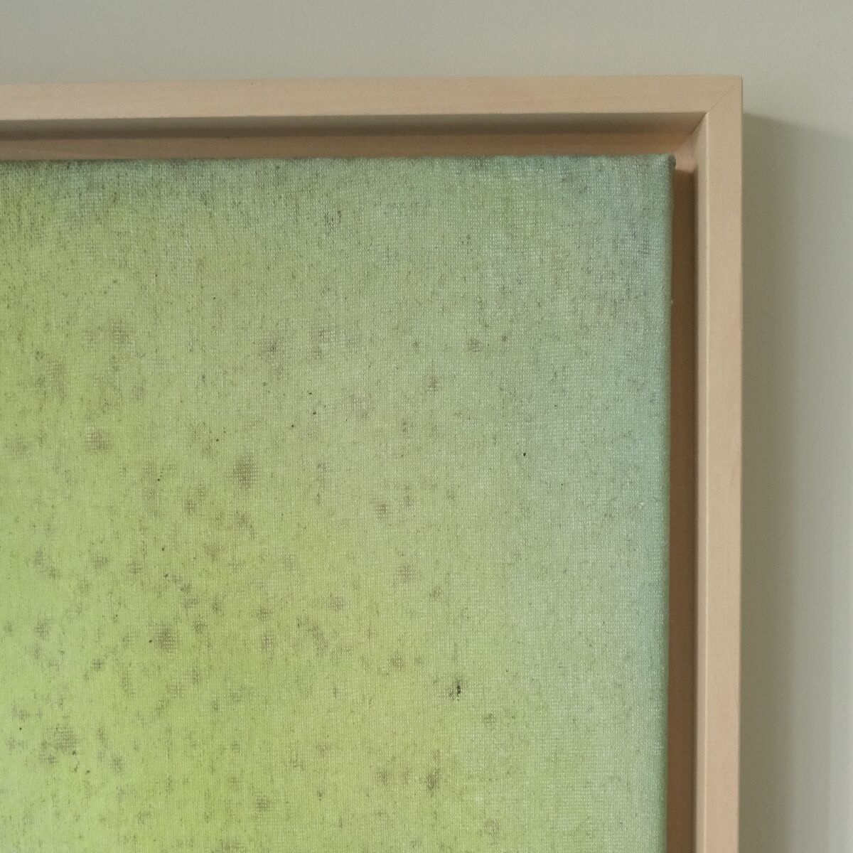 Leinwandbild in einem Holzrahmen mit einer abstrakten Farbmischung aus Gelb, Grün und ein Hauch von Hellblau. Die Farben verlaufen ineinander und haben eine minimalistische, pastellfarbene Ästhetik.