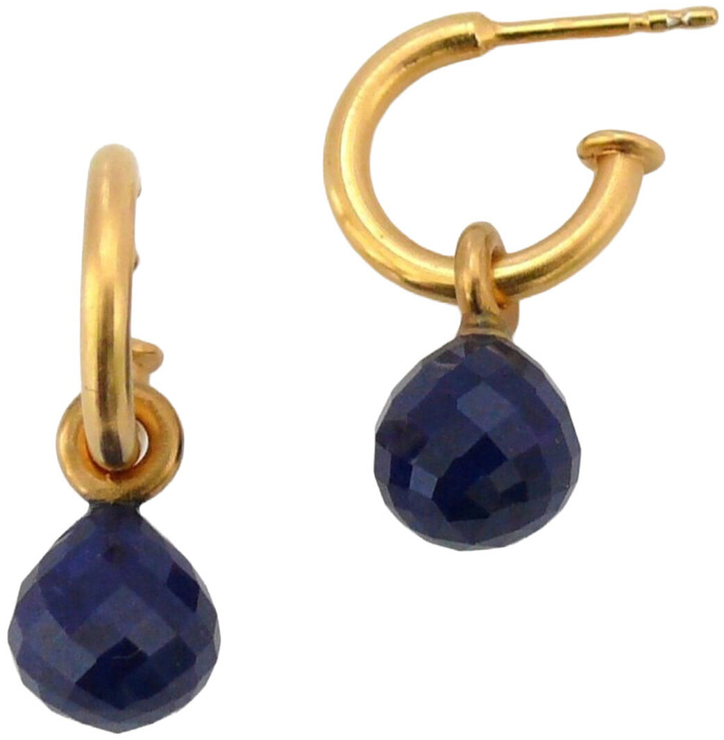 Zwei Creolen-Ohrringe von Dorle Pätzold Schmuck, goldplattiert mit jeweils einem facettierten dunkelblauen Tropfenanhänger aus Lapislazuli. Die Creolen sind schlicht, glänzend und im minimalistischen Design gehalten. Weiße Hintergrundfläche.