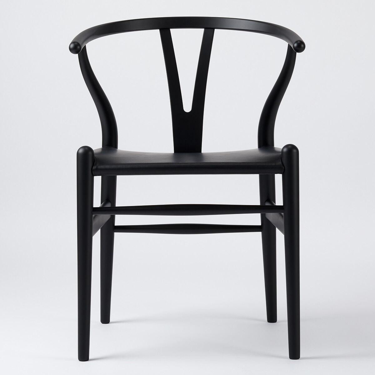Schwarzer Wishbone-Stuhl aus Buchenholz und Leder in minimalistischem skandinavischem Design, ideal für moderne Inneneinrichtung.