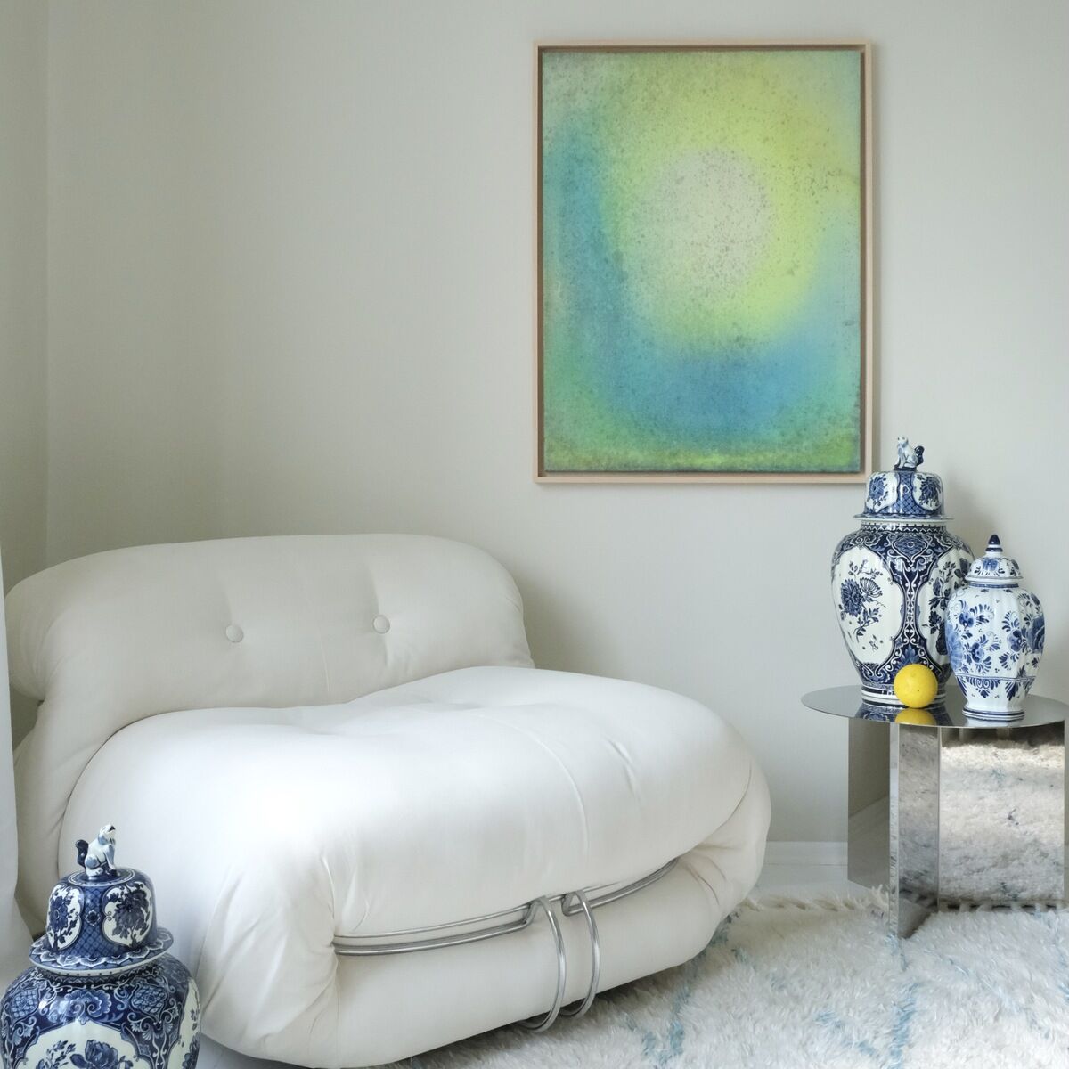 Ein modernes Kunstwerk mit dem Titel 'ZEIT-Sonderedition »SORBET DECONSTRUCTED« Werk 2', das eine pastellfarbene abstrakte Darstellung zeigt. Das Bild hängt an einer Wand, die von blauen und weißen dekorativen Vasen und einem weißen, modernen Sessel sowie einem metallischen Beistelltisch flankiert wird.