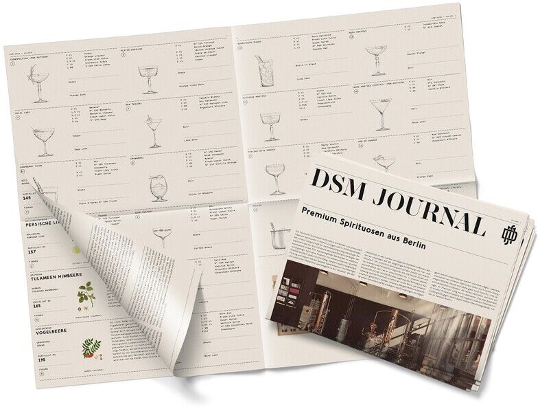Tastingbox Spirituosen-Spezialitäten: Zwei aufgeschlagene Bücher mit Verkostungsnotizen und ein Zeitung mit der Aufschrift 'DSM Journal' liegen auf einem hellen Hintergrund. Enthält detaillierte Informationen über verschiedene Spirituosen.