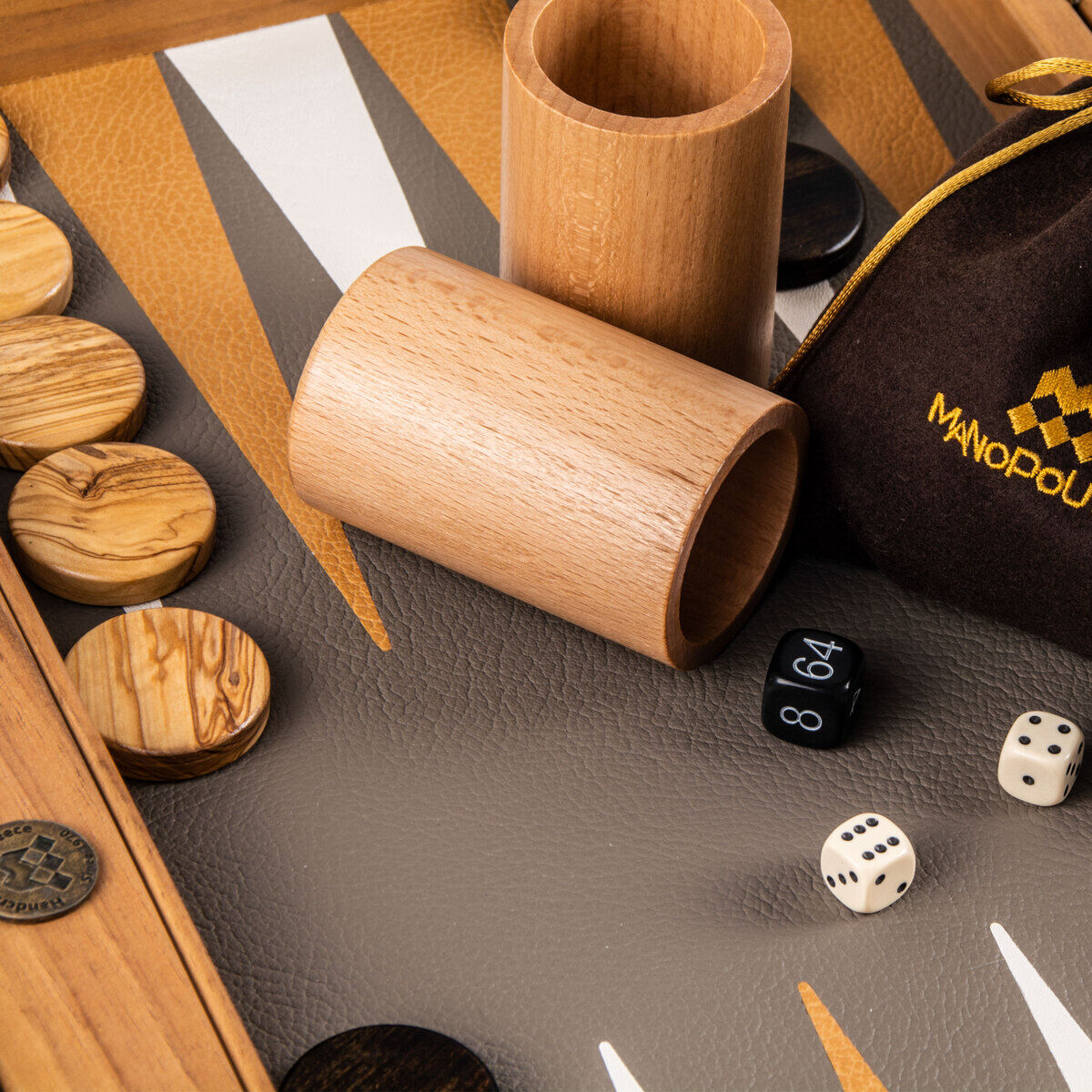 Ein hochwertiges Backgammon-Spiel in grauer und beiger Straußenleder-Optik. Holzfiguren und Würfel sind auf einem detailliert gestalteten Spielbrett platziert. Die Komponenten sind sorgfältig verarbeitet und verleihen dem Gesellschaftsspiel einen luxuriösen Touch.