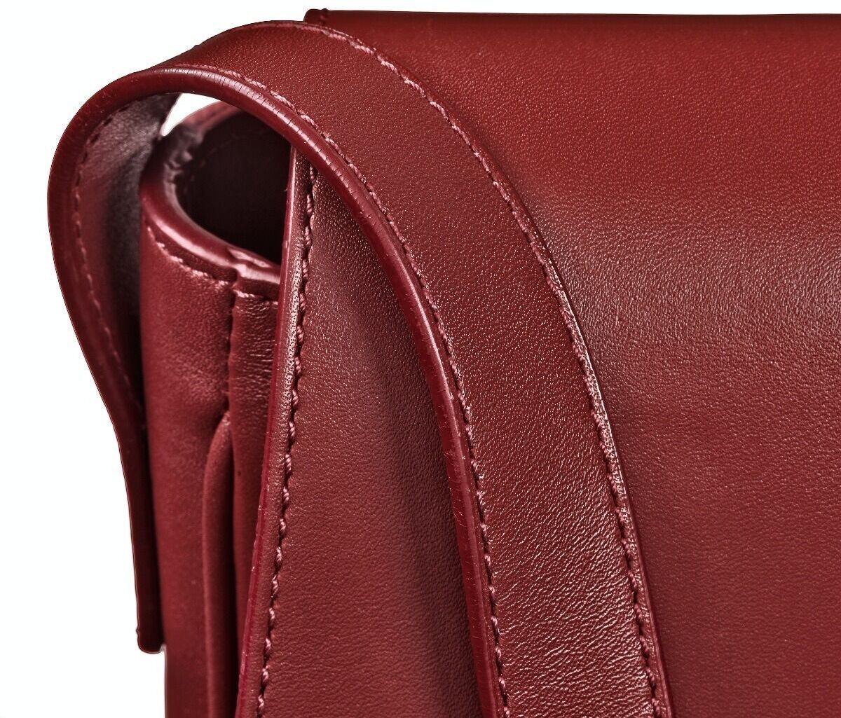 Nahaufnahme einer roten Leder-Umhängetasche im Saddle-Bag-Stil mit detaillierter Naht an der Klappe.