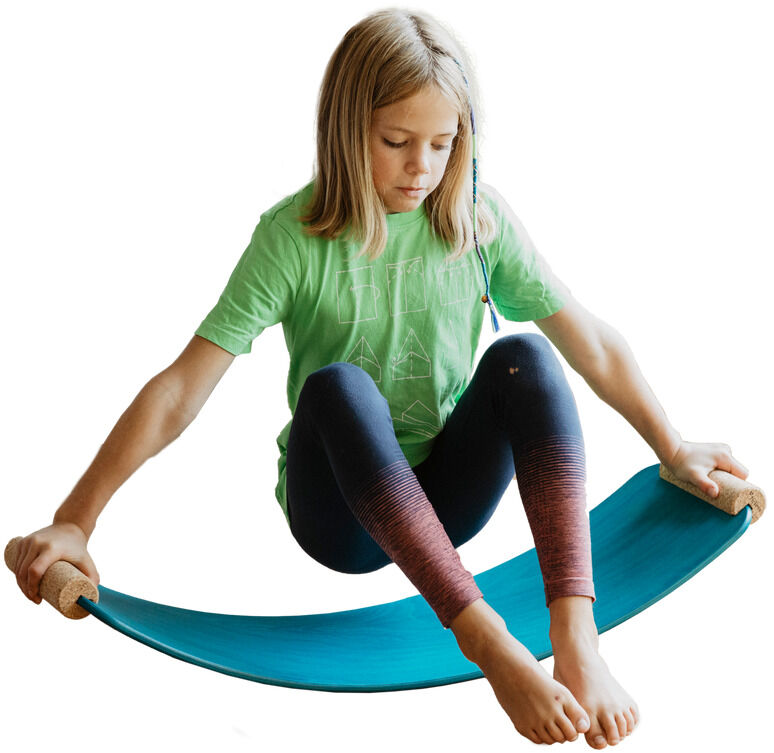 Ein Kind spielt mit einem mintfarbenen Balance-Board (»das.Brett«) und sitzt darauf in einer hockenden Position. Das Balance-Board wird von den Händen gehalten, während die Füße in der Mitte des Brettes platziert sind. Das Kind trägt ein grünes T-Shirt und dunkle Leggings. Hintergrund ist weiß.