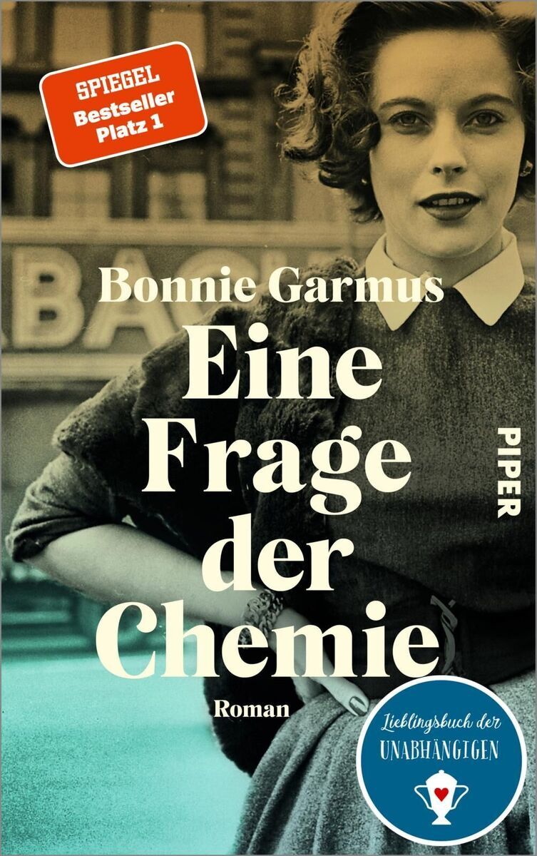 Das Buchcover des Romans 'Eine Frage der Chemie' von Bonnie Garmus zeigt ein schwarz-weiß Bild einer Frau in der Mitte des 20. Jahrhunderts. Das Cover ist überwiegend in schwarz, weiß und blau gehalten. In der oberen linken Ecke befindet sich ein rotes Siegel mit der Aufschrift 'Spiegel Bestseller Platz 1'. Am unteren Rand ist ein blaues Etikett mit der Aufschrift 'Lieblingsbuch der Unabhängigen'.
