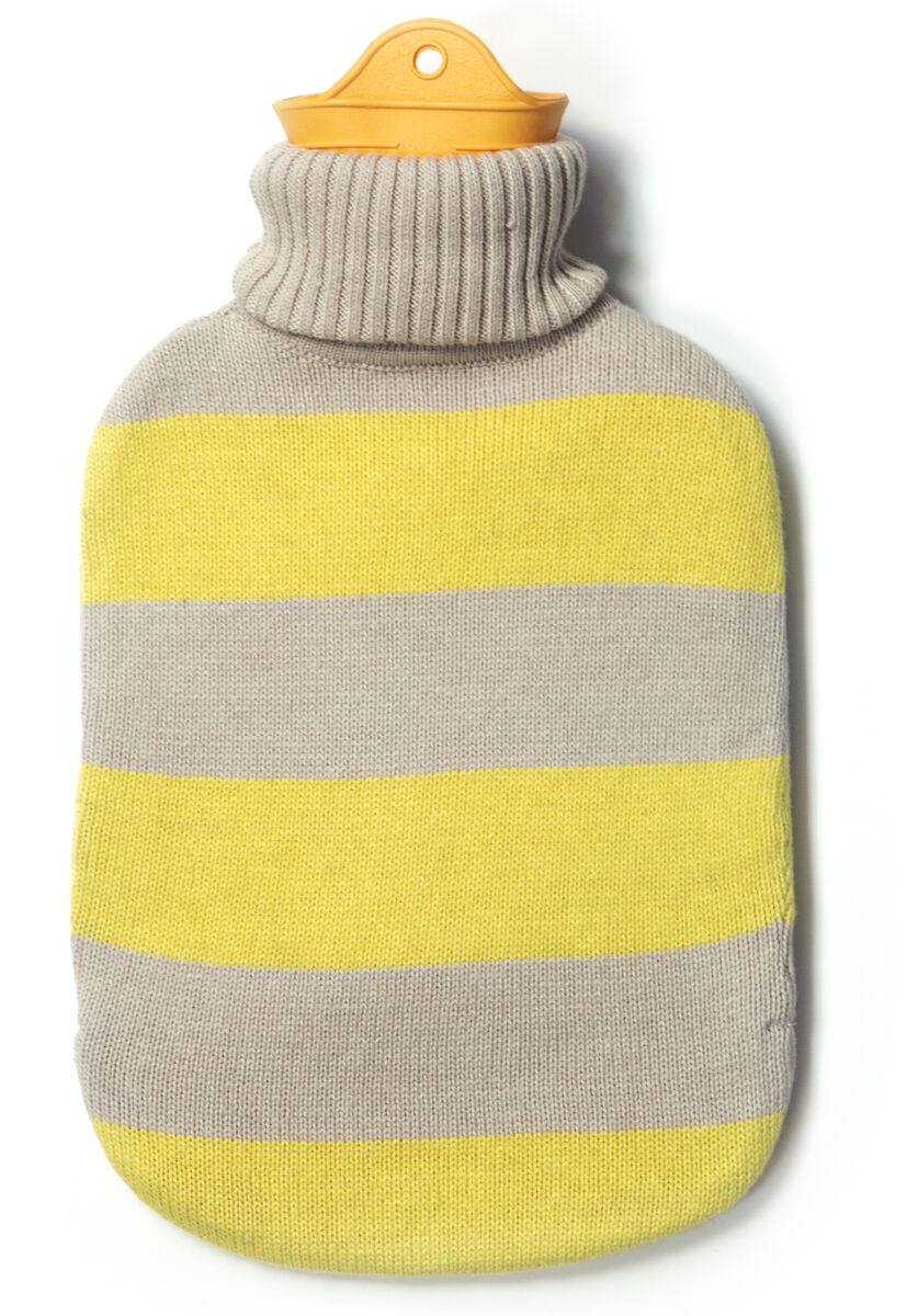 Auf dem Bild ist eine Wärmflasche der Marke SUITE702 zu sehen. Sie hat einen gestreiften Bezug aus 100% Baumwolle in Gelb und Beige, mit breiten horizontalen Streifen und einem orangefarbenen Verschluss aus Latex. Das Design wirkt modern und gemütlich.