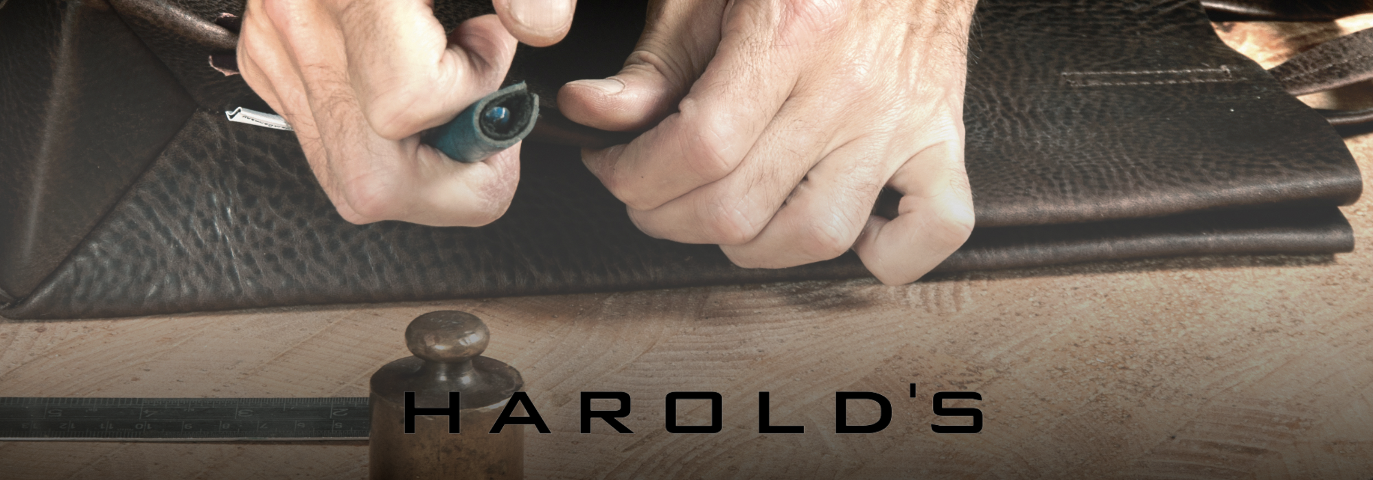 Hände, die schwarzes Leder mit einer Metallschnalle bearbeiten, darunter der Schriftzug 'HAROLD'S'
