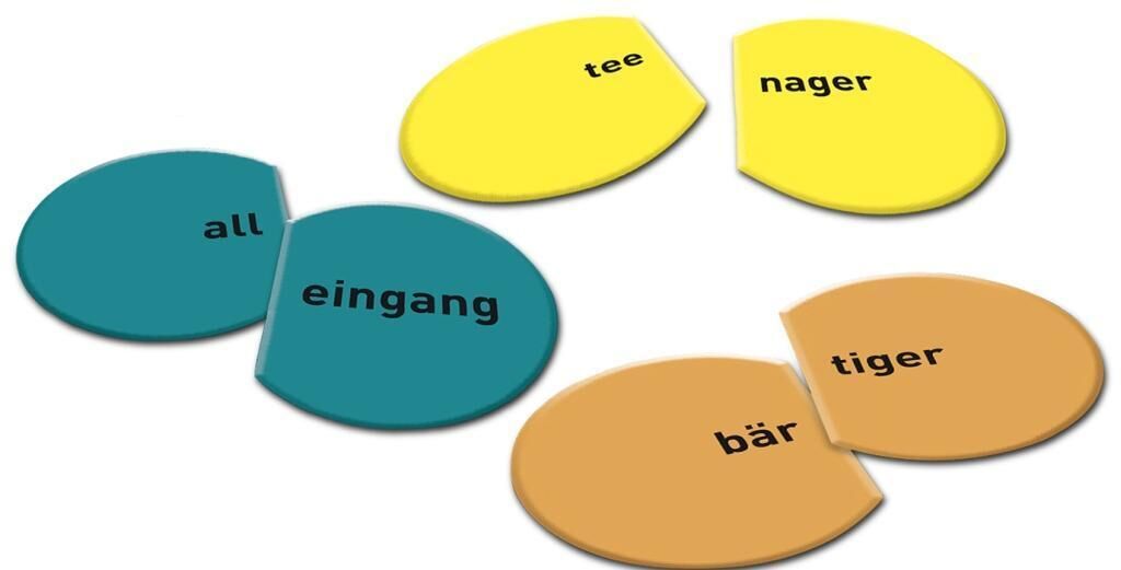Ein Lernspiel mit verschiedenen farbigen Kreisen, die in zwei Hälften geteilt sind und jeweils ein Wort darauf gedruckt ist. Die Hälften können kombiniert werden, um vollständige Wörter zu bilden.