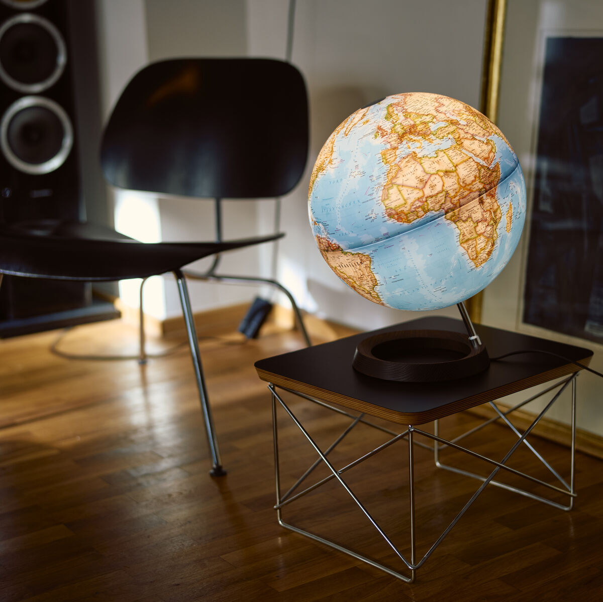 Ein beleuchteter Globus von National Geographic auf einem modernen Tisch in einem stilvoll eingerichteten Raum. Der Holzboden und die eingerahmten Bilder im Hintergrund ergänzen die ästhetische Atmosphäre.