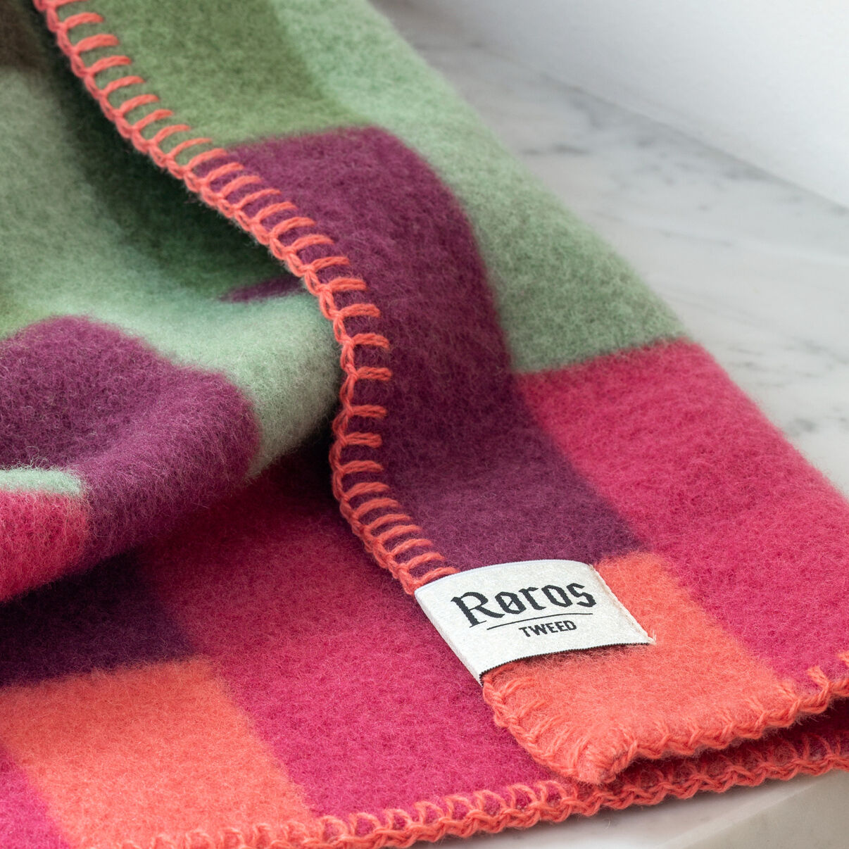 Roros Tweed Wollschal mit grünem, lila und orangefarbenem Karomuster und orangefarbener Ziernaht
