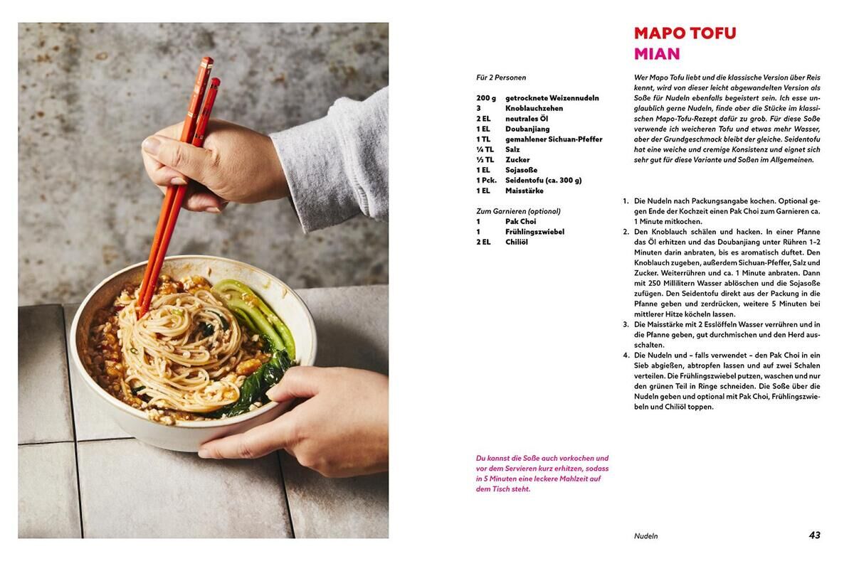 Eine Person hält eine Schüssel Nudeln mit roten Essstäbchen. Auf der rechten Seite befindet sich eine Seite aus einem Kochbuch mit dem Titel 'Mapo Tofu Mian' und einem Rezepttext.