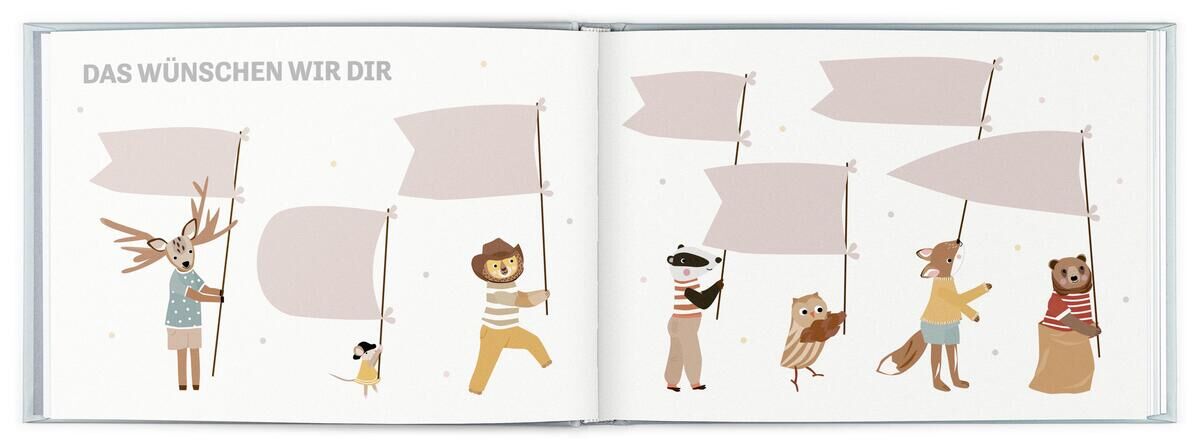 Ein aufgeschlagenes Kinderbuch zeigt auf zwei Seiten mehrere Tiere, darunter ein Hirsch, Löwe, Eule, Maus, und Bär, die Banner halten. Der Text auf der linken Seite lautet: 'DAS WÜNSCHEN WIR DIR.'