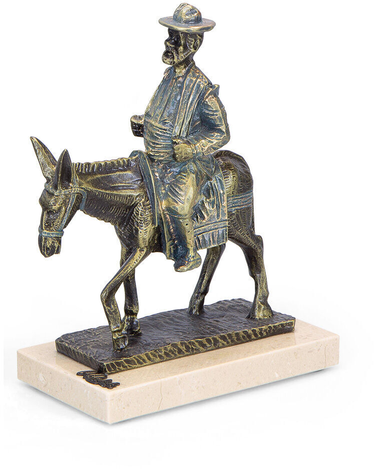 Eine Skulptur von Angeles Anglada zeigt Don Quijote und Sancho Panza auf einem Esel. Die detailreiche Figur in Bronzeoptik steht auf einem hellen Sockel. Besonders geeignet für Kunstliebhaber und Fans von Literatur.