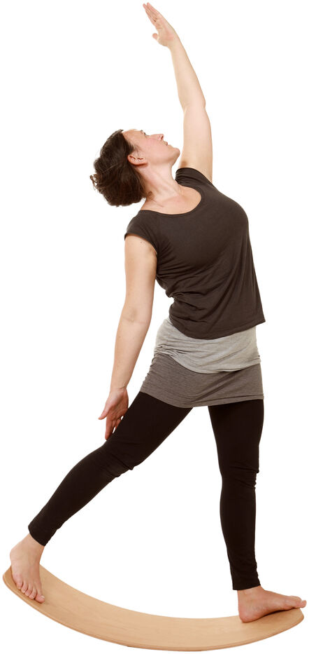 Eine Person übt eine Yoga-Position auf einem geölten Balance Board »das.Brett«, das aus Holz besteht.