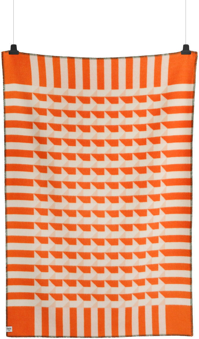 Lammwolldecke »KVAM« in orange-weißem Streifenmuster hängt an zwei schwarzen Klammern vor weißem Hintergrund.