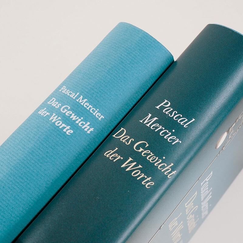 Zwei Bücher von Pascal Mercier mit dem Titel 'Das Gewicht der Worte' in blauen und grünen Einbänden.