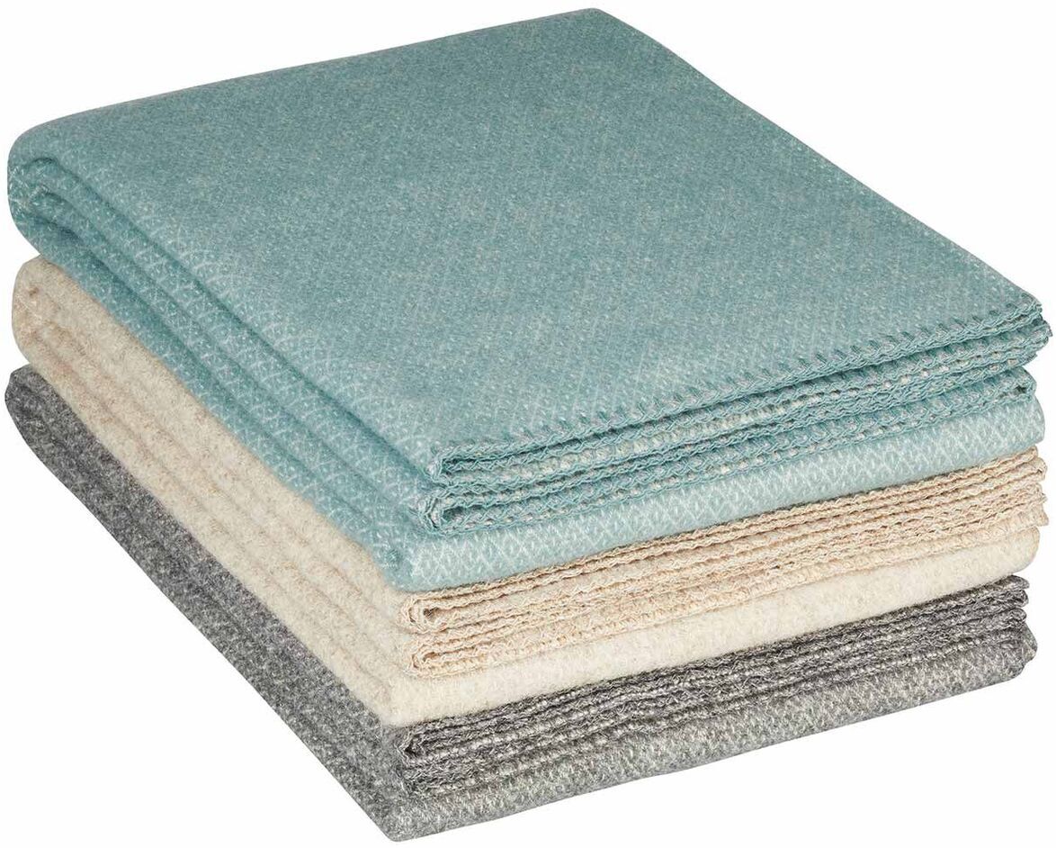 Gestapelte Decken in den Farben Grau, Beige und Hellgrün.