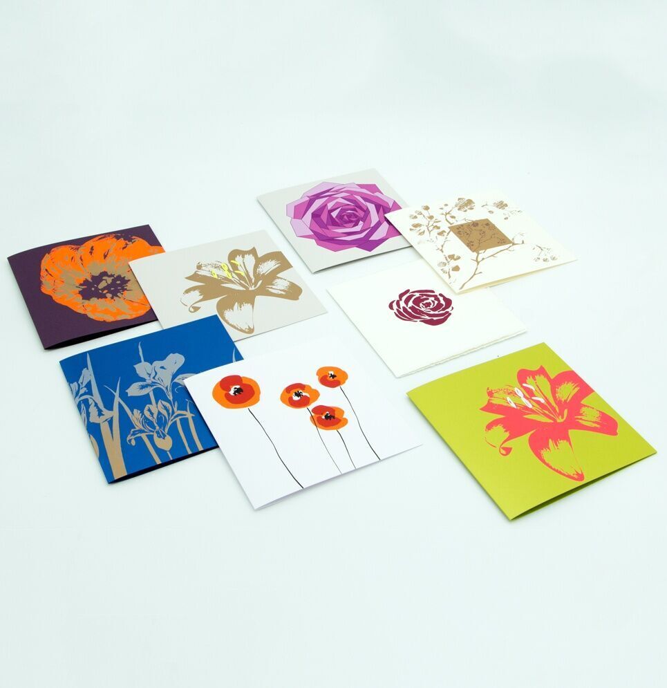 Ein 8-teiliges Set von Grußkarten mit floralen Designs, die verschiedene Blumenmuster in bunten Farben enthalten, auf einem hellen Hintergrund arrangiert.