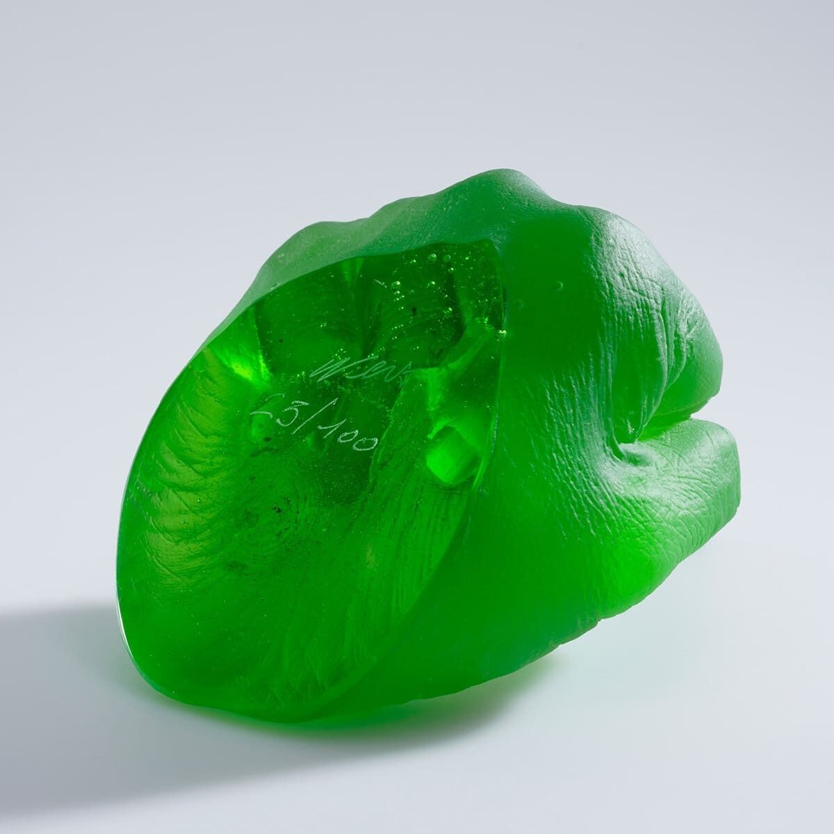 Ein Foto der Glaskunst-Skulptur 'Study of Perspective in Glass' von Ai Weiwei. Die Skulptur ist grün und zeigt die Form eines menschlichen Fingers. Sie hat eine transparente Textur und feine Details.