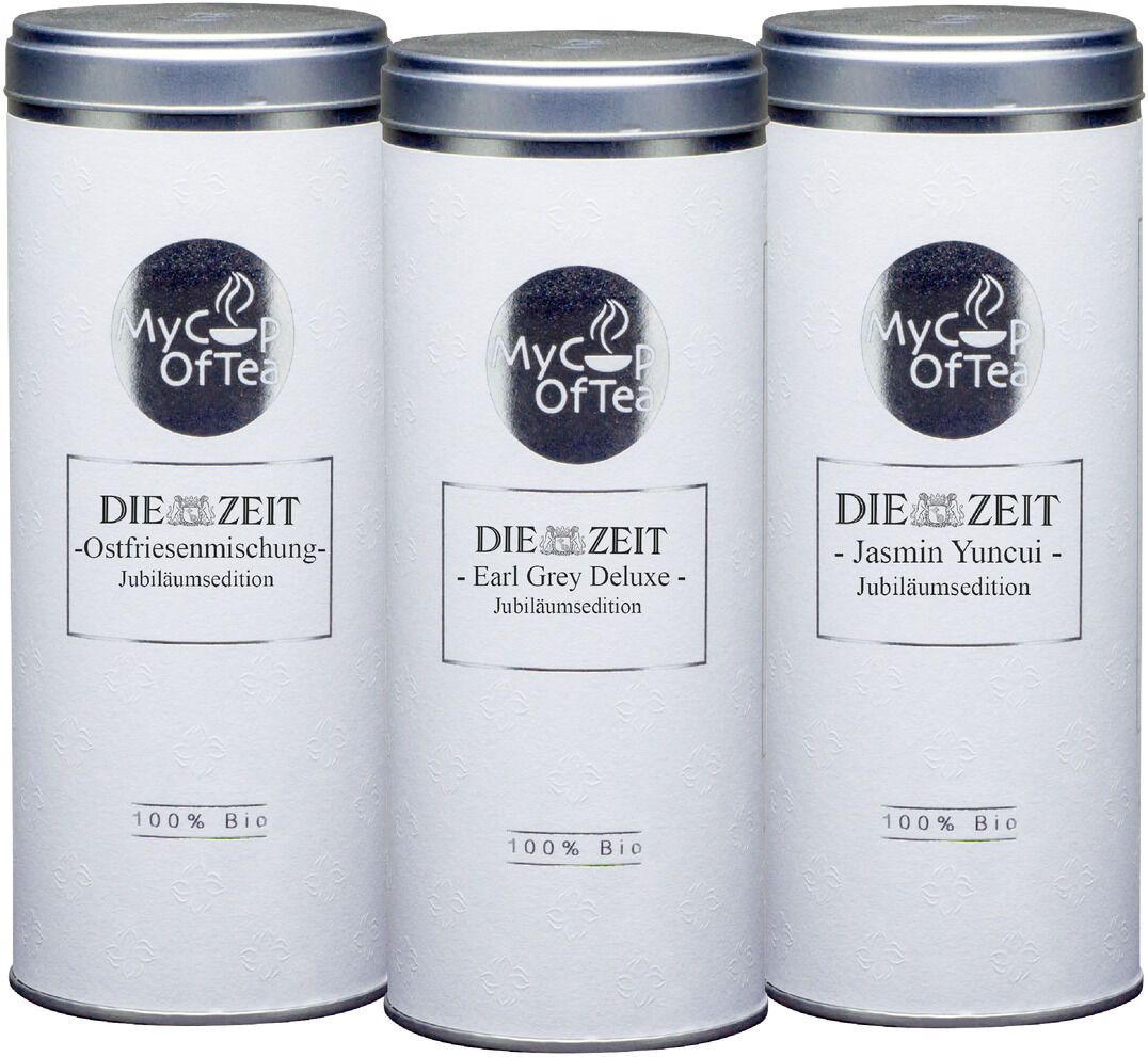 Das ZEIT-Jubiläumsedition Tee-Set besteht aus drei zylindrischen Teedosen mit silbernen Deckeln und einer weißen Oberfläche mit schwarzer Schrift. Jede Dose trägt das Logo 'MyCupOfTea' und die jeweilige Teesorte: Ostfriesenmischung, Earl Grey Deluxe und Jasmin Yuncui.