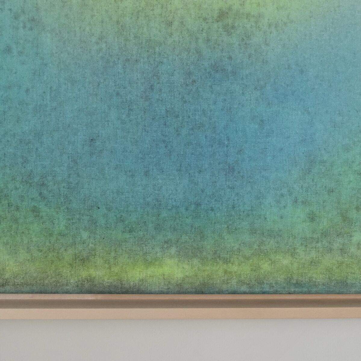 Ein abstraktes Gemälde mit einem Farbverlauf von Grün und Blau, gerahmt in Holz.