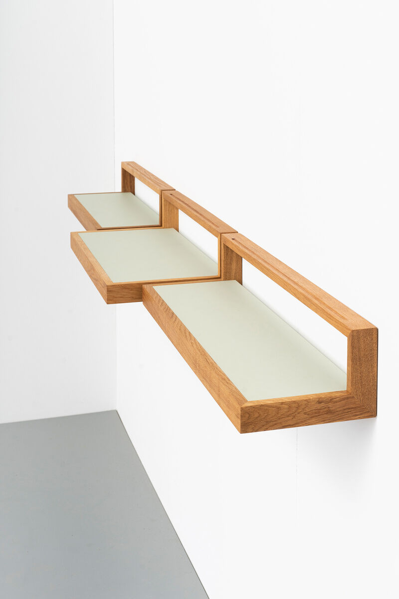 Das Bild zeigt ein Wandregal namens »buck« in der Farbe Pistazie. Das Regal hat ein modernes Design und besteht aus Holz. Es besteht aus drei Ablageflächen, die an einer weißen Wand montiert sind. Der Boden des Regals ist hellgrau. Dieses Möbelstück eignet sich gut für die Inneneinrichtung.