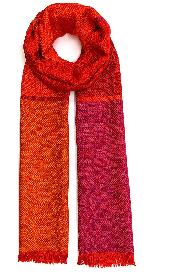 Ein Seidenschal in den Farben Rot, Orange und Pink, gefaltet und auf einem weißen Hintergrund fotografiert. Der Schal hat eine luxuriöse Textur und ist ein stilvolles Modeaccessoire.