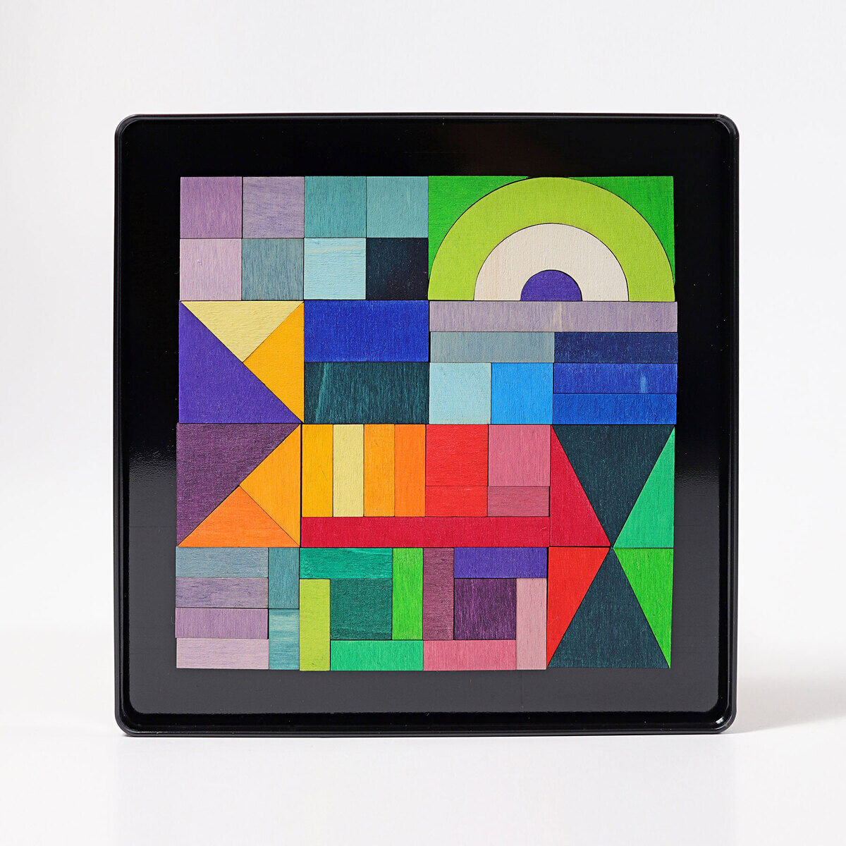 Ein magnetisches Holzspielzeug mit dem Namen »Geo-Grafisch«. Es besteht aus verschiedenen bunten geometrischen Formen, die auf einer schwarzen Metallfläche angeordnet sind.