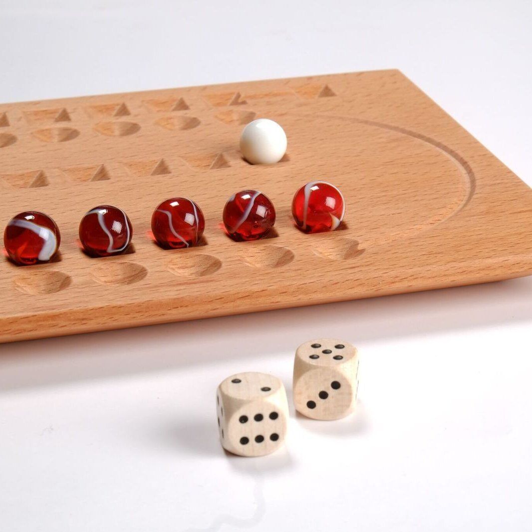 Ein Holzbrettspiel mit einem perforierten Holzbrett und weinroten Glasmurmeln. Das Set enthält weiße Würfel mit schwarzen Punkten und rote sowie weiße Murmeln.