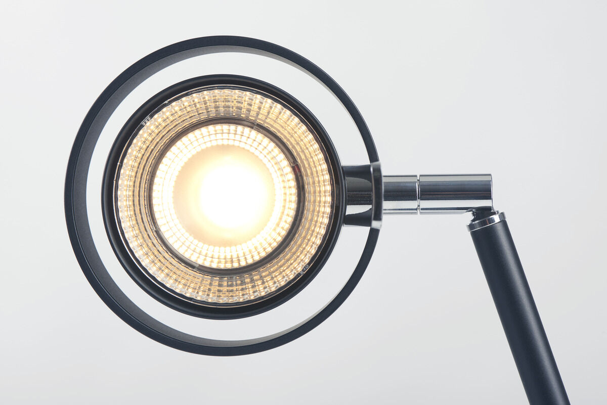 ZEIT-Jubiläumsedition Tischleuchte »Pure« mit modernem und minimalistischem Design. Die Lampe hat einen schwarzen Metallrahmen und eine zentrale LED-Lichtquelle, die von einem silbernen Halter getragen wird.
