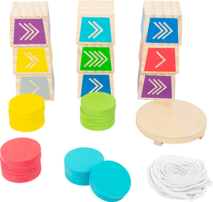 Das Bild zeigt drei Türme aus Holzblöcken mit bunten Pfeilen in Gelb, Grün, Blau und Pink. Vor den Türmen liegen farblich passende Wurfchips und ein Seil.