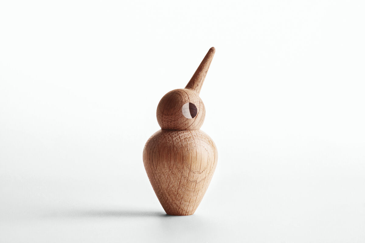 Holzfigur eines Vogels aus Naturholz in minimalistischem Design, stehend vor einem weißen Hintergrund