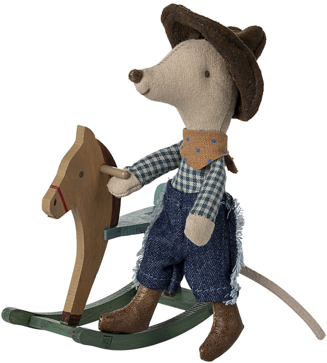 Eine Stoffmaus im Cowboy-Outfit reitet auf einem kleinen Schaukelpferd. Die Maus trägt einen braunen Hut und ein kariertes Hemd, während sie auf einem grün-braunfarbenen Schaukelpferd sitzt. Das Bild vermittelt eine verspielte und abenteuerliche Stimmung.