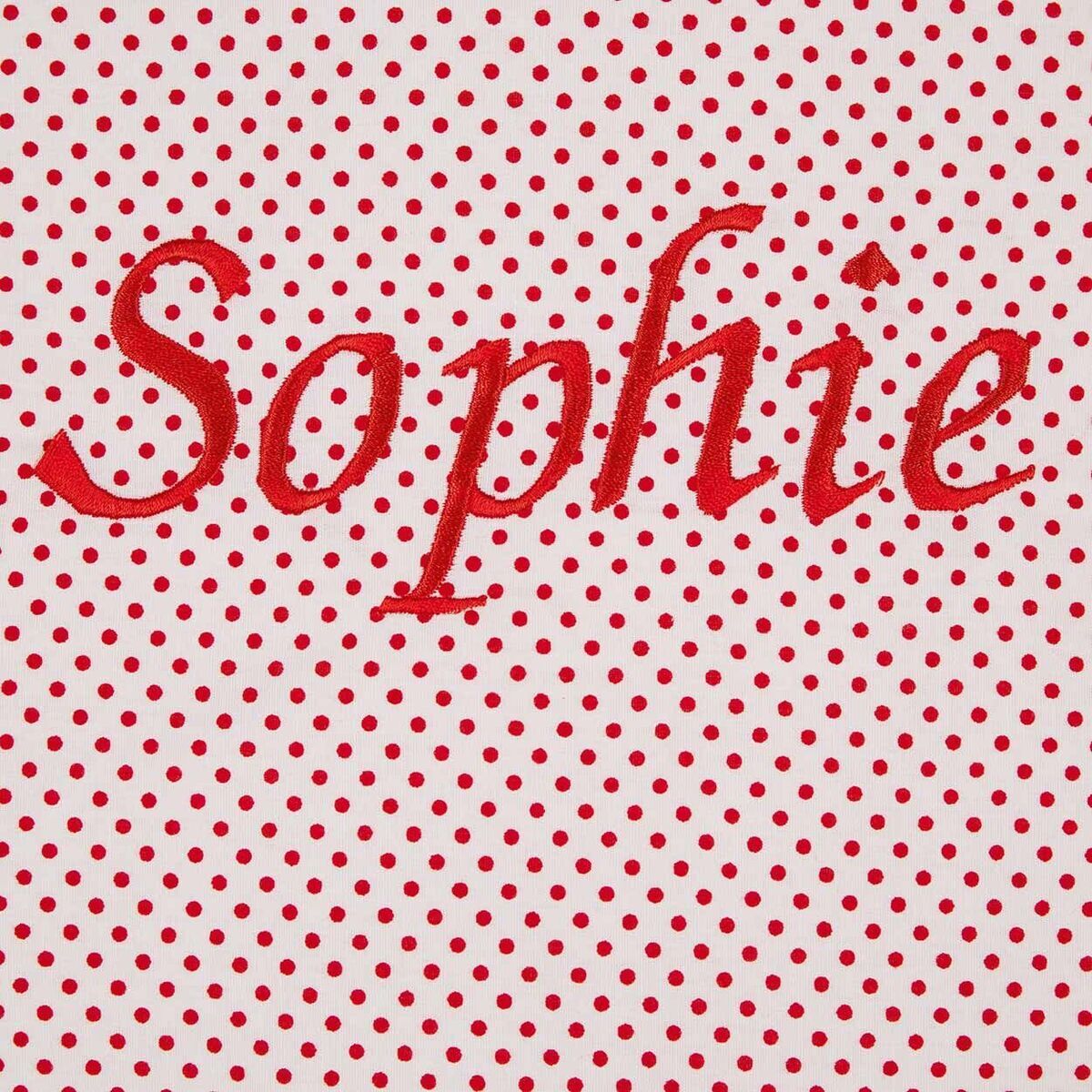 Rote Polka-Dots-Muster mit dem gestickten Namen 'Sophie' in roter Schrift auf einem weißen Hintergrund.