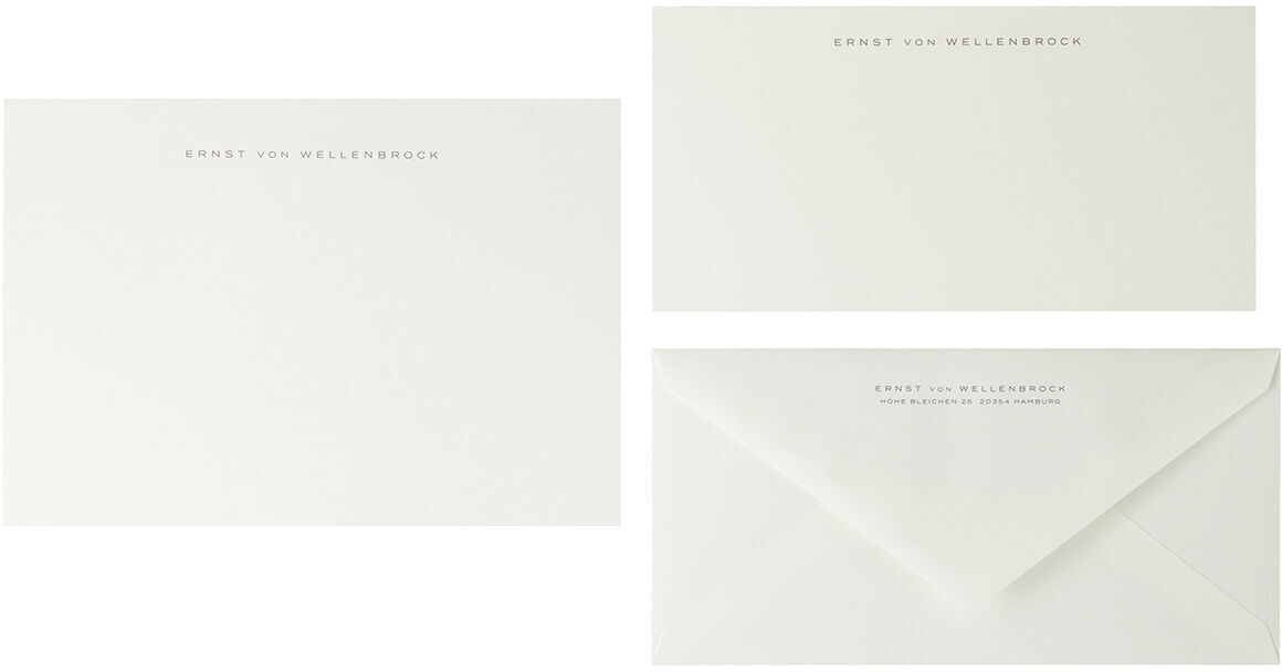 Ein Set aus drei Briefpapierelementen in Miniformat in den Farben Weiß und Anthrazit. Enthalten sind zwei bedruckte Bögen und ein bedruckter Briefumschlag.