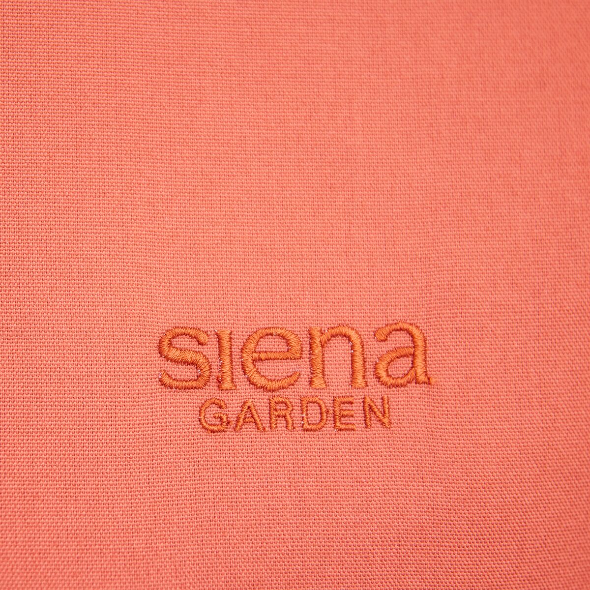 Nahaufnahme des korallfarbenen Stoffbezugs der Swingliege »Aliano« mit gesticktem siena garden Logo. Der strukturierte Stoff wirkt modern und gemütlich, ideal für Garten, Balkon oder Terrasse.