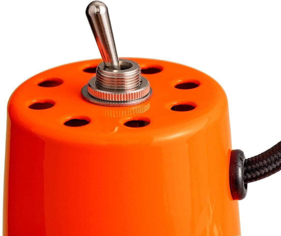 Nahaufnahme einer orangefarbenen Stehleuchte der ZEIT-Sonderedition »Federzug« mit einem Metallschalter auf der Oberseite und einem schwarzen Kabel, das seitlich herausragt.