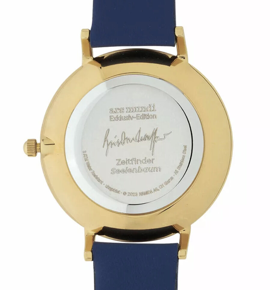 Rückansicht einer exklusiven Künstler-Armbanduhr von Friedensreich Hundertwasser, Modell »Zeitfinder Seelenbaum« mit goldfarbenem Gehäuse, blauem Armband und einer signierten Rückseite.