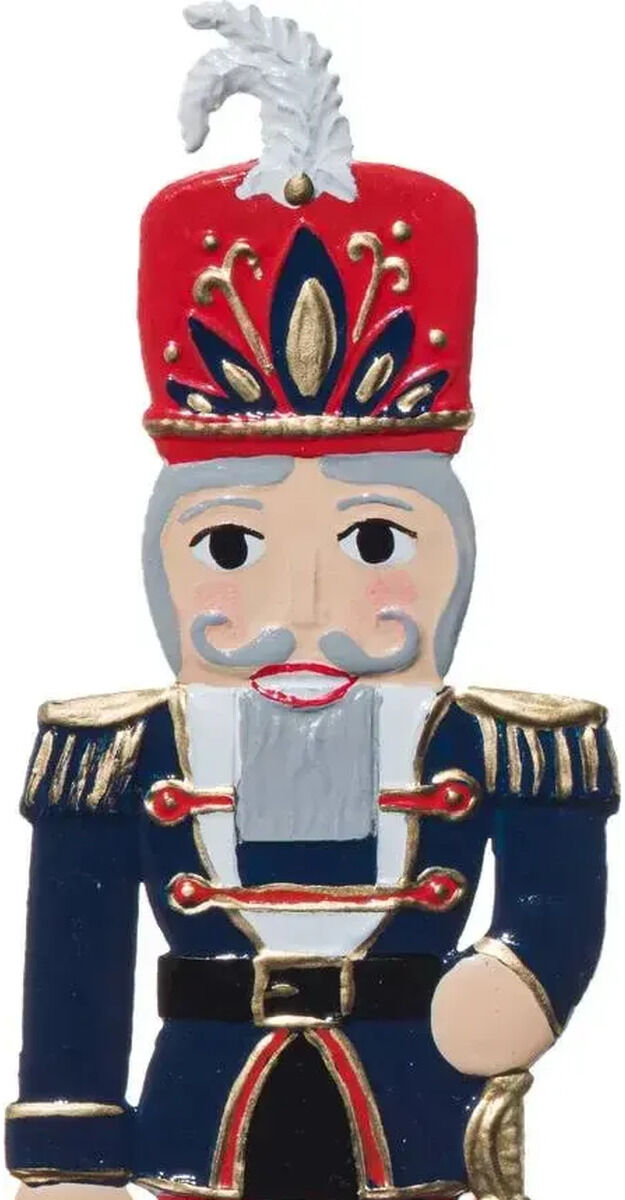 Freigestellte Zinnfigur eines Nussknacker-Soldaten auf weißem Grund. Die handbemalt wirkende Figur trägt rote Hose und hohen roten Hut mit silberner Feder, dunkelblaue Uniformjacke mit goldenen Schulterfransen sowie schwarze Stiefel. In der rechten Hand hält sie einen silbernen Säbel.