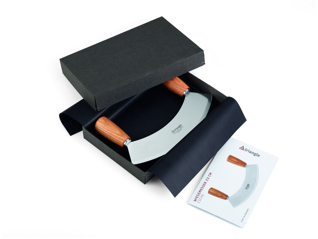 Das Bild zeigt ein Wiegemesser 'Soul' in einer schwarzen Geschenkbox. Das Messer hat einen Edelstahlklingen und Holzgriffe. Neben der Box liegt eine Broschüre mit der Aufschrift 'Wiegemesser Soul'.