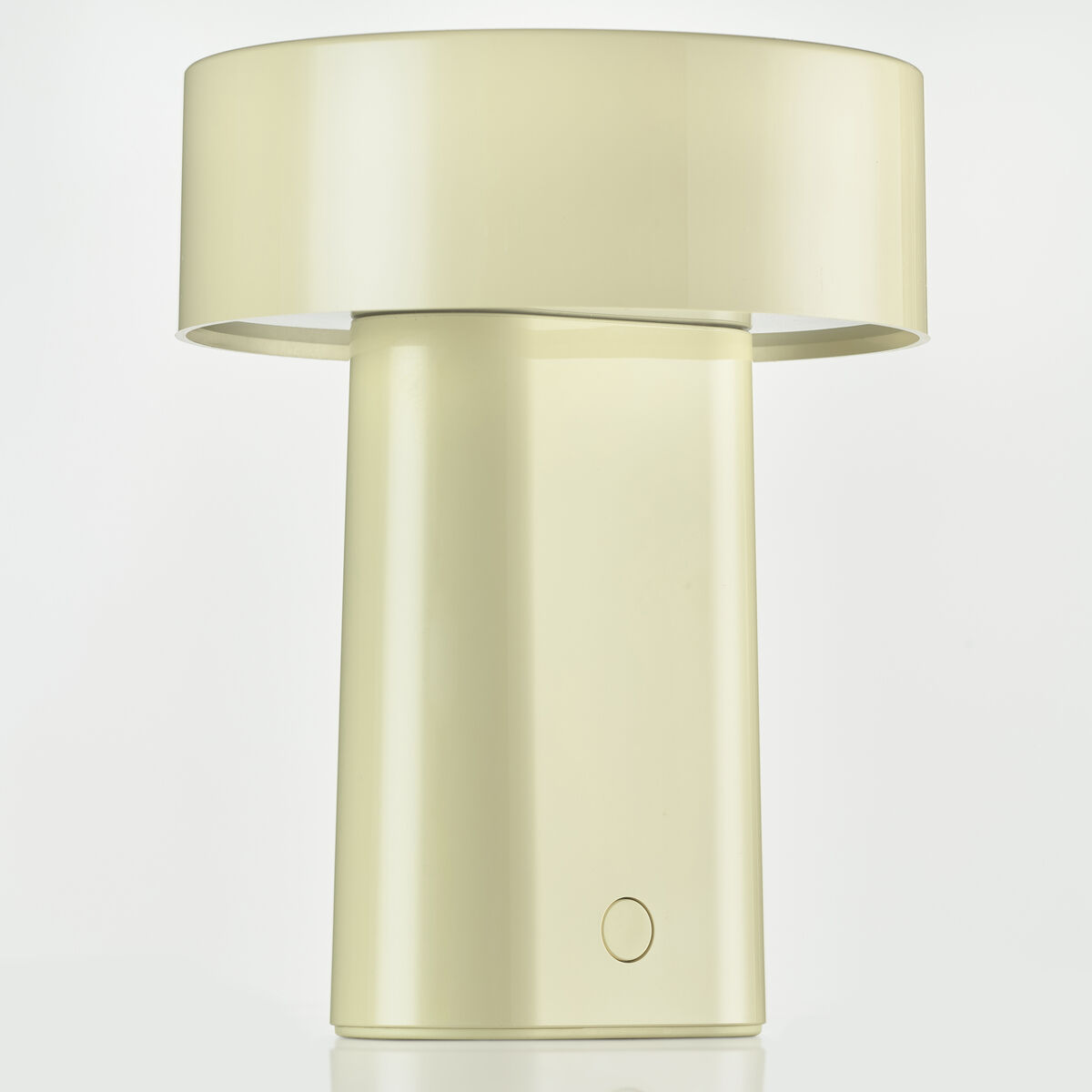 Die Abbildung zeigt eine tragbare Tischlampe namens „Oblong“ in cremefarbener Optik, mit minimalistischem Design, zylindrischem Lampenfuß und breitem, rundem Lampenschirm. Die Lampe steht auf einer spiegelnden Oberfläche vor hellem Hintergrund.