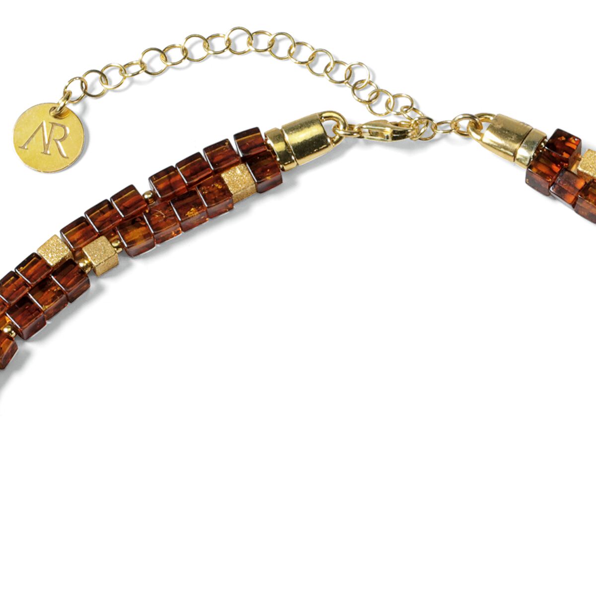 Detailansicht eines Colliers aus dem Bernstein-Schmuckset »Annabele« von Ars mundi. Die Halskette besteht aus würfelförmigen Bernsteinperlen in warmem Braunton, eingefasst mit goldfarbenen Zwischenelementen und einer goldenen Schließe mit Logo-Anhänger.