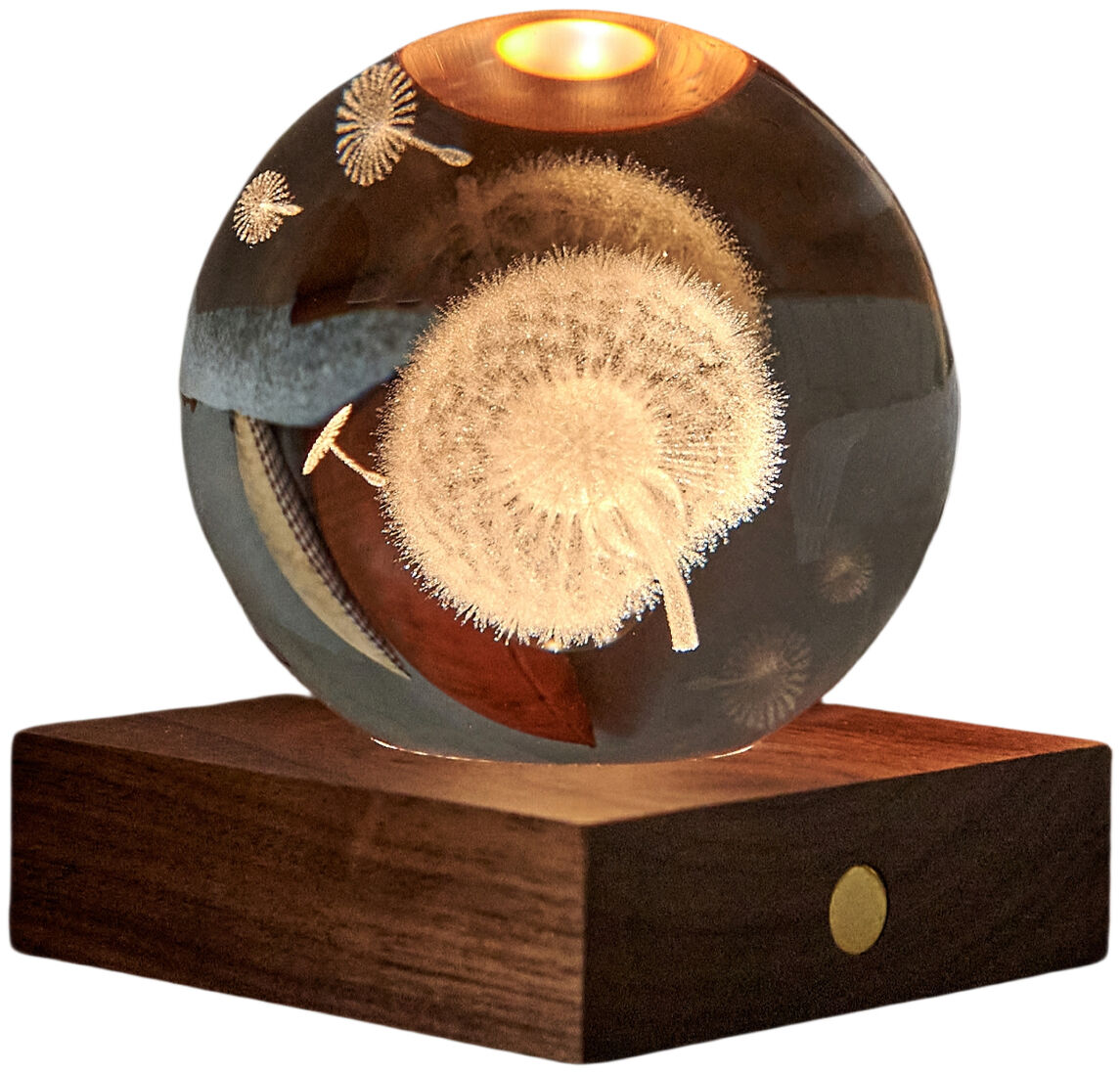Eine edle Kristallglas-Kugel mit 3D-Lasergravur einer Pusteblume ruht auf einem massiven, dunklen Walnussholzsockel. Aus der oberen Sockelmitte strahlt Licht nach oben in die Kugel, wodurch die Gravur effektvoll hervorgehoben wird. Die Szene wirkt hochwertig und modern.