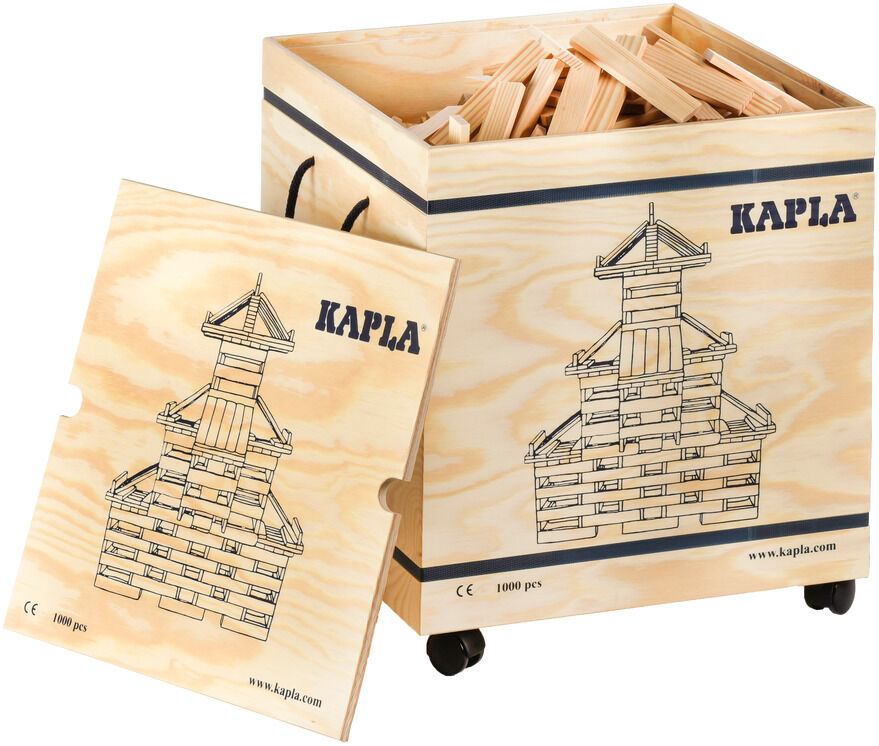 Eine Holzkiste mit der Aufschrift 'Kapla' und einer Abbildung eines Gebäudes, das mit Holzbausteinen gebaut wurde. Die Kiste ist geöffnet und Holzbausteine sind sichtbar.