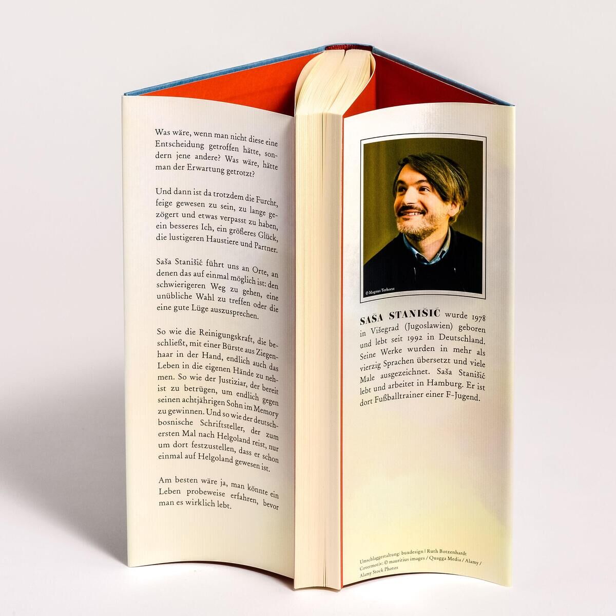 Offenes Buch mit dem Titel 'Stanisic, S: Möchte die Witwe angesprochen werden, platziert sie auf dem Grab die Gießkanne mit dem Ausguss nach vorne'. Auf der rechten Seite ist ein Porträt des Autors und Text zu sehen, Rückseite des Deckelumschlags ist leicht orange.