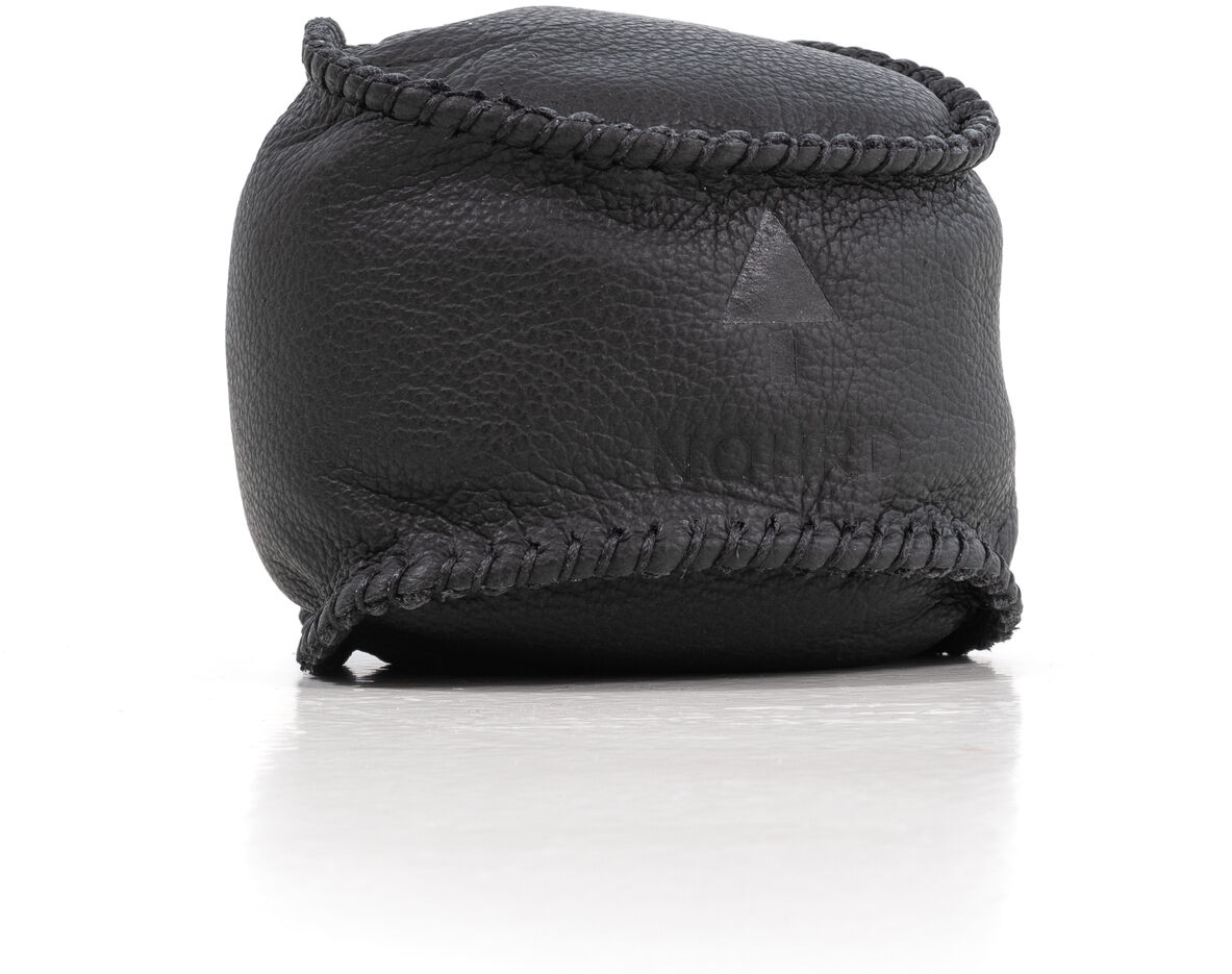 Ein HaptikBall in schwarzem Leder auf einer weißen Oberfläche. Der Ball scheint klein und kompakt zu sein, spezifisch gestaltet zur Handgymnastik und Stressabbau.