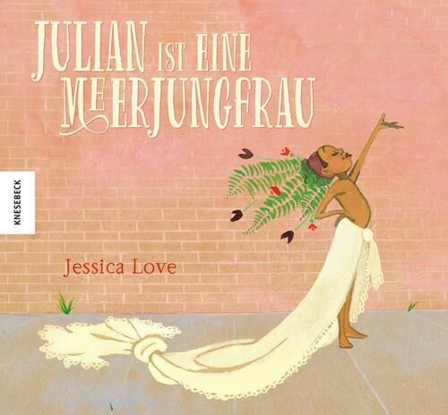 Das Buchcover zeigt eine fantasievolle Illustration aus dem Buch 'Julian ist eine Meerjungfrau' von Jessica Love. Ein Kind in einem selbstgemachten Meerjungfrauen-Kostüm mit grünem Kopfschmuck posiert stolz auf einem beigefarbenen Hintergrund. Große, kunstvolle Schrift zeigt den Titel und den Namen der Autorin.